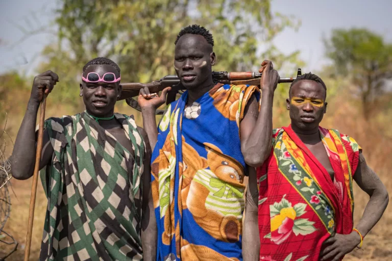 Three Karo tribesmen of the Omo Valley region in Southwest Ethiopia, in not so traditional garb
